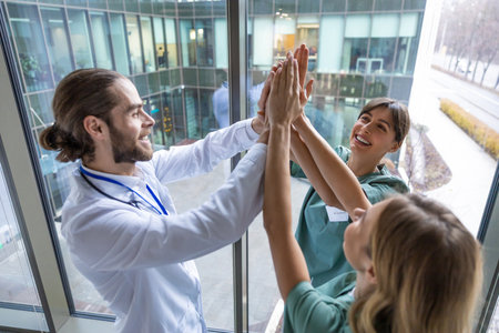 Group of doctors holding hands together and looking positive and smilingの写真素材