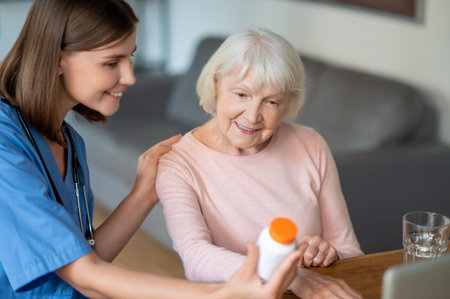 Female doctor explaining to elderly patient painkiller usage instructionsの写真素材