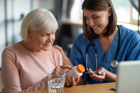 Nurse explaining elderly woman patient medications in medical clinic or in hospice careの写真素材