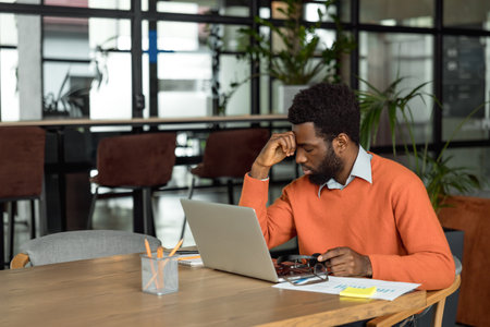 African american entrepreneur looking tired after hours of overtimeの写真素材
