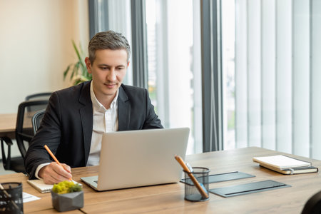Caucasian young businessman working in the office and looking busyの写真素材