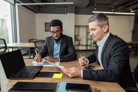 Business consultant talking to the client and looking involvedの写真素材