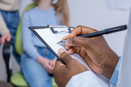 Close up picture of ophthalmologist writing a prescription to a small patientの写真素材