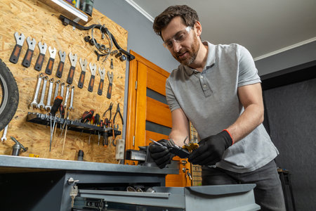 Mechanic in black gloves inspecting toolsの写真素材