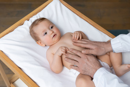 Cute little baby boy in diaper looking sweet and happy in the doctors officeの写真素材