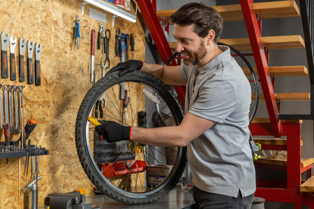 Mechanic in black gloves lifting wheelの写真素材