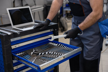 Mechanic working with tools and laptopの写真素材