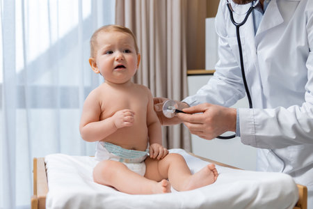 Cute little baby boy having an exam at the doctors officeの写真素材