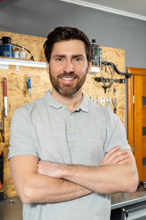 Mechanic standing with arms crossed in workshopの写真素材