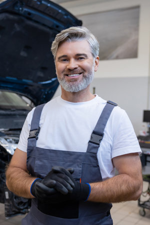 Mechanic holding gloves in workshopの写真素材