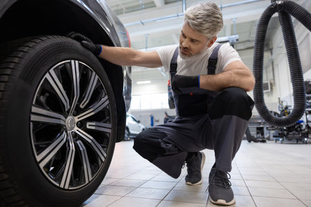 Mechanic checking vehicle wheelの写真素材