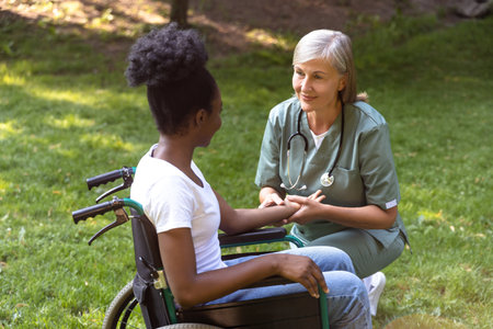 Nurse and a female on a wheelchair in the parkの写真素材