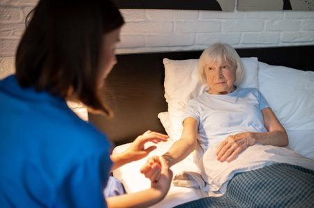 Doctor checking pulse of an elderly patient
