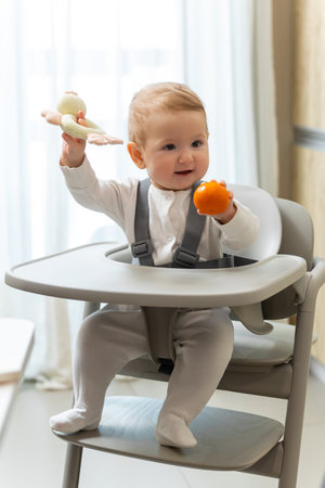 Cute small baby boy sitting in his chair and playingの写真素材