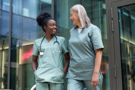 Two female doctors talking and looking contented and confidentの写真素材
