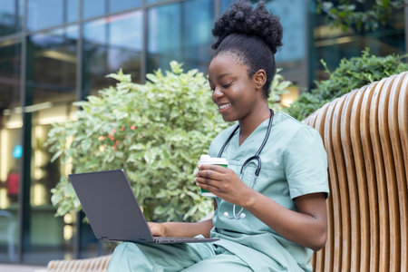 African american young doctor sitting on the bench and having coffeeの写真素材
