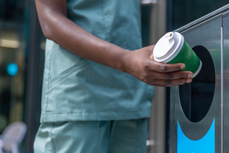 Close up picture of a woman throwing waste to the sorting waste binの写真素材