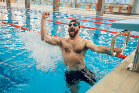 Man in swimming pool feeling excited and happyの写真素材