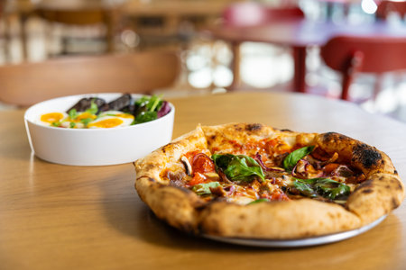 Picture of a table with plates with pizza in pizzeriaの写真素材
