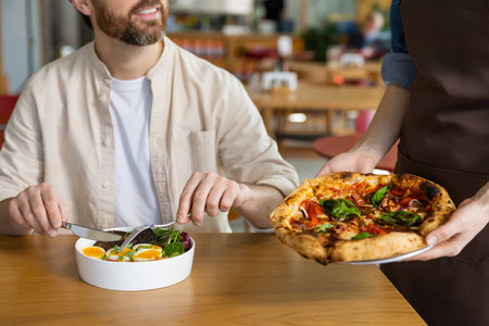 Client getting his pizza in pizzeria and looking contentedの写真素材