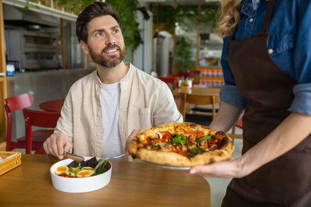 Client getting his pizza in pizzeria and looking contentedの写真素材