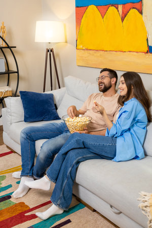 Man and woman sitting on couch watching TVの写真素材