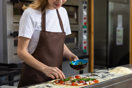 Woman preparing pizza in kitchenの写真素材