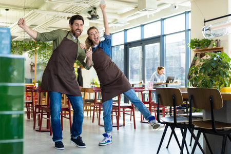 Man and woman waiters celebrating at restaurantの写真素材