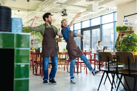 Man and woman waiters celebrating at restaurantの写真素材