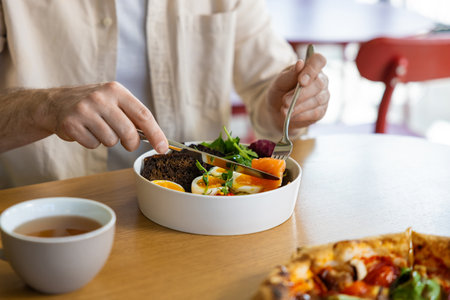 Person eating salad at restaurantの写真素材