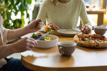 Friends enjoying meal together at restaurantの写真素材