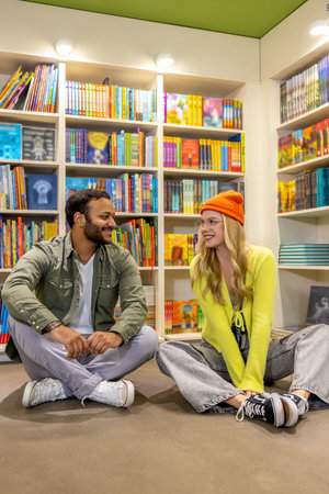 Multicultural man and woman in library togetherの写真素材