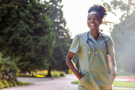 Portrait of medical worker standing in park with green backgroundの写真素材