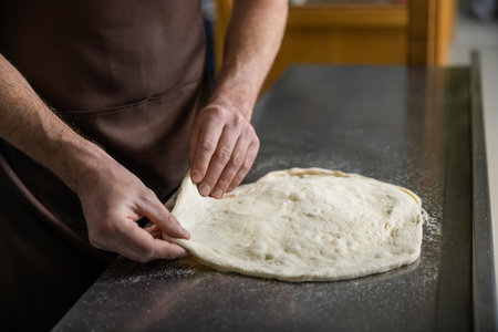 Close up picture of cooker working with dough for pizzaの写真素材