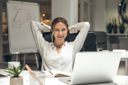 Office worker analyzing data on laptop with notepadの写真素材