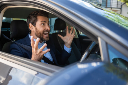 Excited businessman sitting in the car and looking emotional