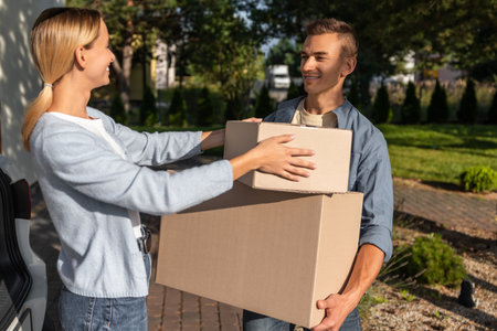 Young couple packing clothes into boxes and getting prepared for the moving in