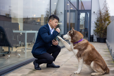 Young man in a suit standing near the business center entrance with a dog next to him