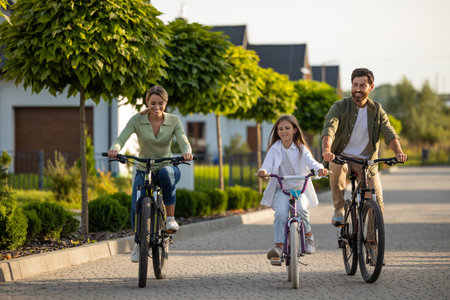 Family bike outing on residential path with trees and homesの写真素材