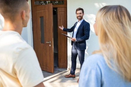 Male real estate agent presenting a new house to the clientsの写真素材