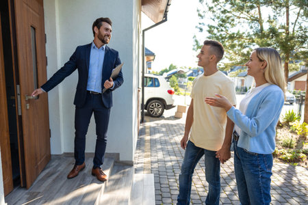 Male real estate agent presenting a new house to the clientsの写真素材