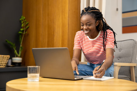 Young african american woman working online from home and looking involved
