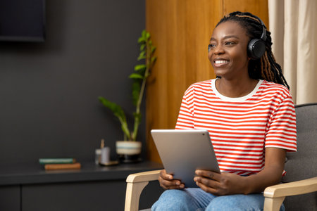 Young woman in headphones sitting at laptop and looking busy