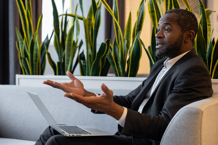 Businessman with a laptop having a talk and looking emotional