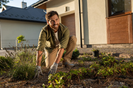 Man working in the cottage garden and planting the flowers