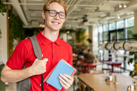 Young ginger man in eyeglasses looking confident and smiling nicelyの写真素材