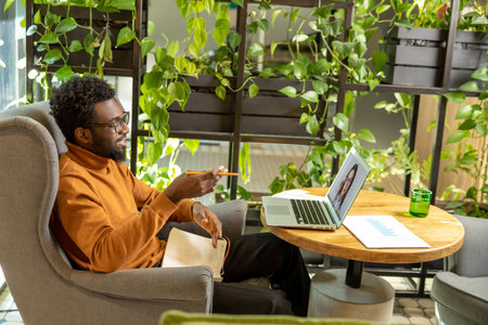 African American male in turtleneck participating in business video call