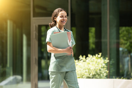 Smiling female doctor walking with files in her hands