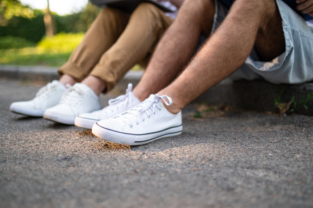 Teens sitting on the pavement in the park together