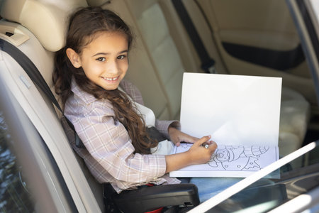 Sweet girl of school age in the car drawing and looking peacefulの写真素材